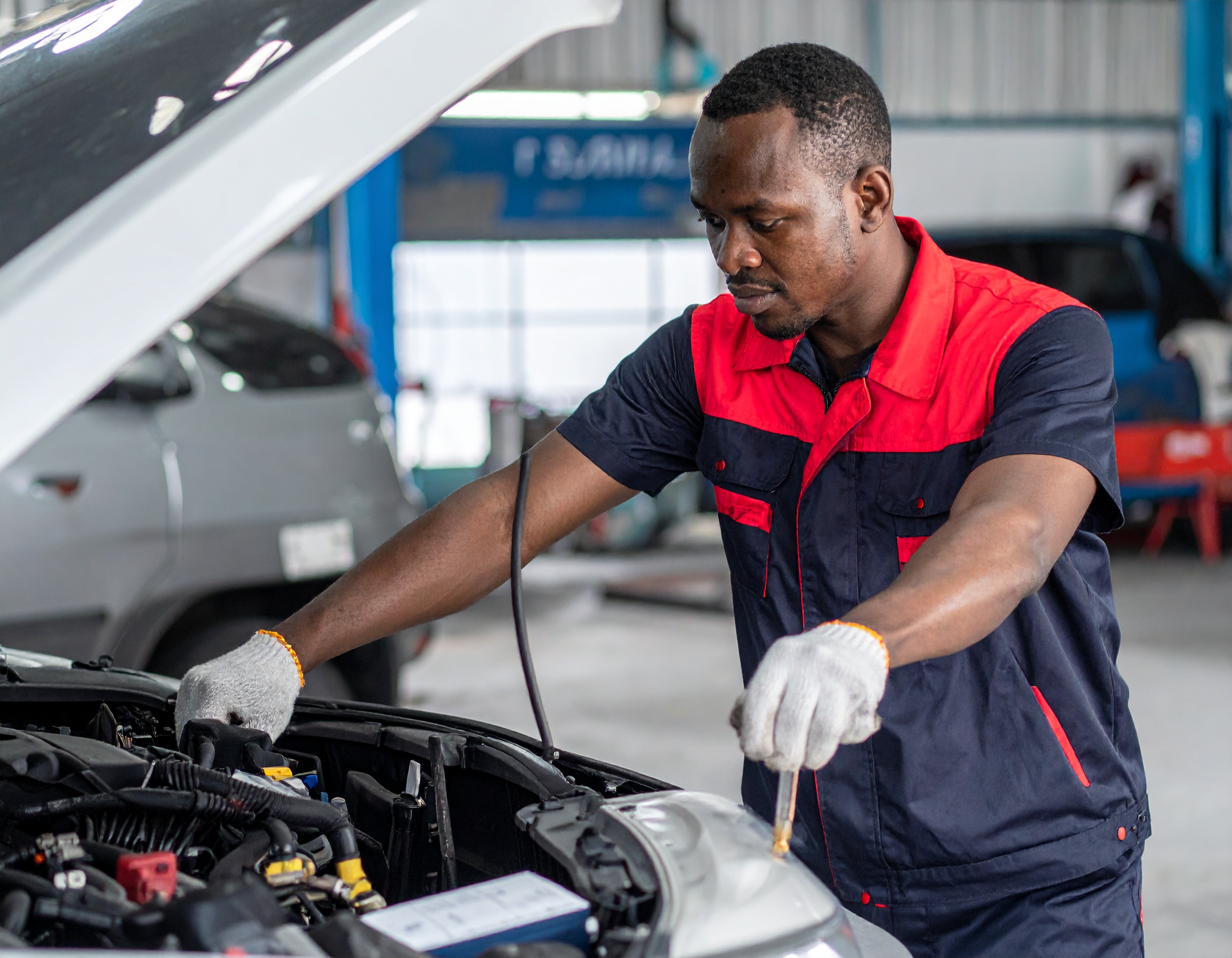 Firefly create images of Tyre & Battery Services preformed by african technician the technician must